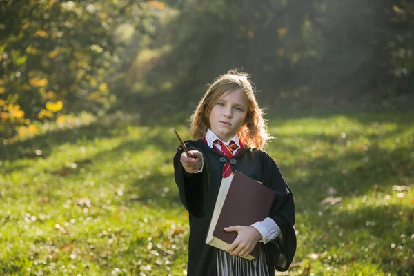  Witch girl with magic wand cosplay wizzard outdoor. Halloween holiday. Halloween costume.
