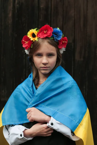 Állítsa meg a háborút Ukrajnában. Szőke tini lány hagyományos ukrán ruhát ukrán zászló. Béke Ukrajnában koncepció. — Stock Fotó