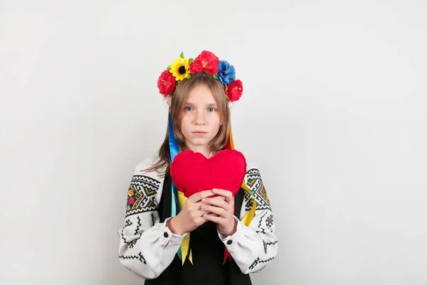 Állítsa meg a háborút Ukrajnában. Szőke tini lány hagyományos ukrán ruhában, vörös szívvel. Béke Ukrajnában koncepció. — Stock Fotó