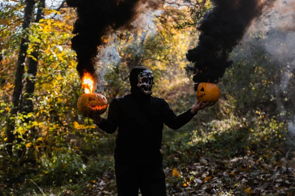 Portret Przerażającego Człowieka Szkieletowej Masce Lesie Potwór Trzymając Płonące Dynie — Zdjęcie stockowe