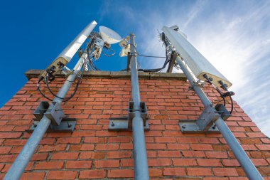 Telekomünikasyon veri ekipmanları, radyo panel antenleri, açık hava uzaktan kumanda üniteleri, güç kabloları, eş eksenli kablolar, optik lifler için metal yapılar olan tuğla duvar. Dışardaki parça