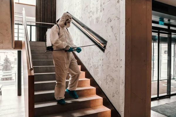 Covid19保護 防護服を着た男がホテルの正面玄関の階段を滅菌しています 保護環境 コロナウイルス 旅行の安全性 — ストック写真