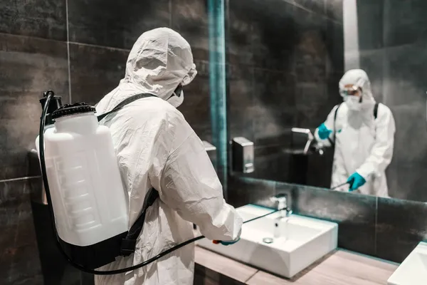 コロナウイルスの危険 男性の保護服の専門家は ホテルのトイレでの感染症の広がりを防ぐ 健康でCovid 19への警告 — ストック写真