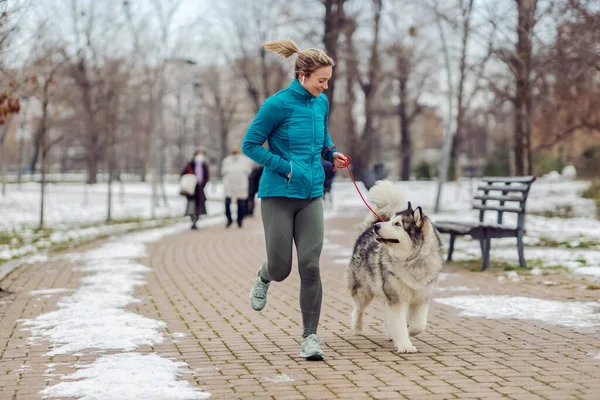 Sportswoman Jogging Insieme Con Suo Cane Nel Parco Tempo Nevoso — Foto Stock