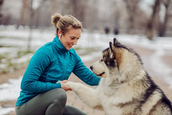 Sportkvinnan Lär Sin Hund Att Skaka Hand Medan Han Hukar — Stockfoto