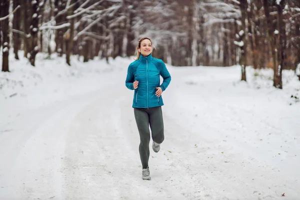 눈내리는 겨울날 속에서 달리는 스포츠맨 — 스톡 사진