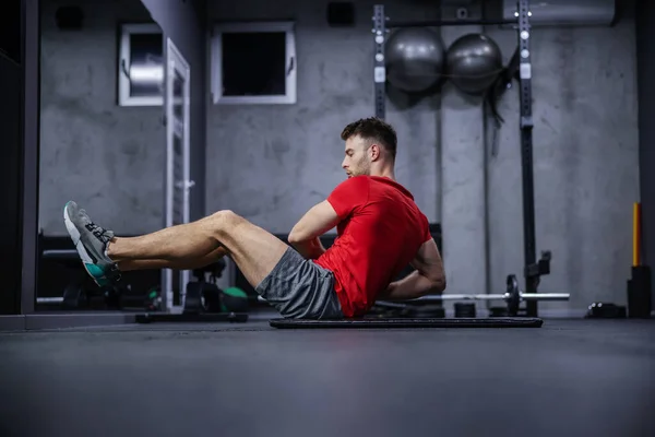 근육을 강화하는 앉아서 체육관 바닥에 셔츠와 반바지를 있습니다 스포츠의 로열티 프리 스톡 이미지