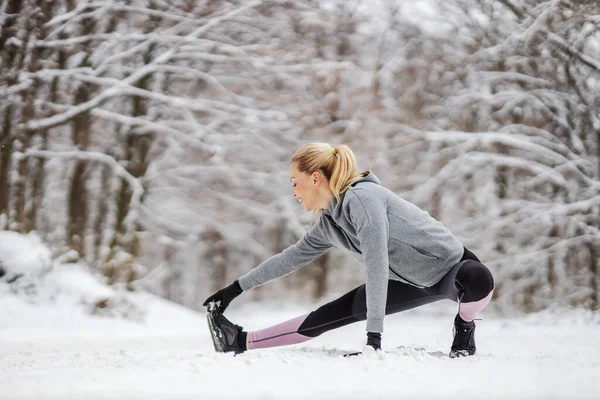 Flexible Fit Sportswoman Crouching Nature Doing Warmup Stretching Exercises Snowy — Stock Photo, Image