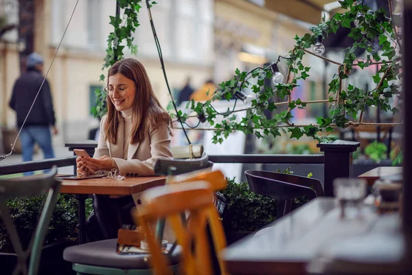 Lächelnder Influencer Sitzt Cafeteria Und Nutzt Handy Zum Aufhängen Sozialen — Stockfoto