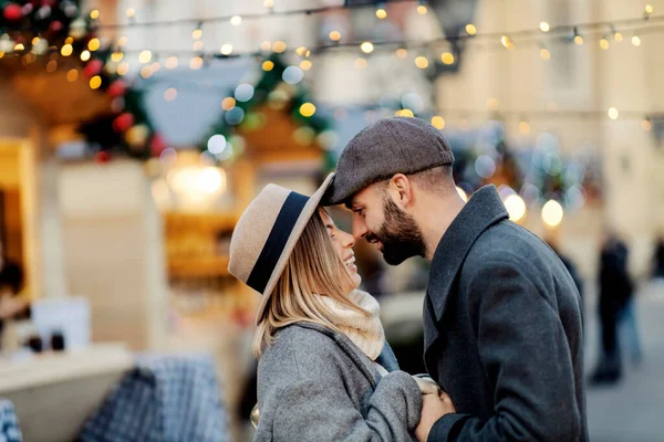 クリスマスはお正月に通りで抱き合うのが大好きです 路上に立つ若い幸せな恋人 手を取り合って新年を抱きしめる — ストック写真