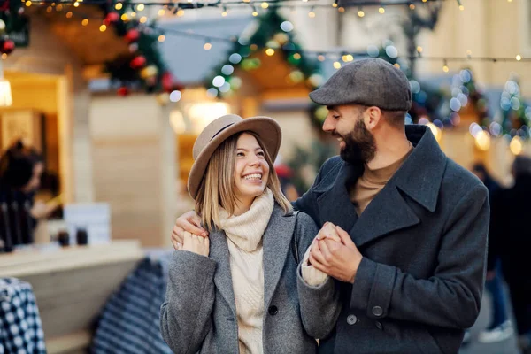 クリスマスのカップルはクリスマスの日に通りを歩く 幸せなカップルの愛の抱擁とクリスマスの通りを歩く — ストック写真
