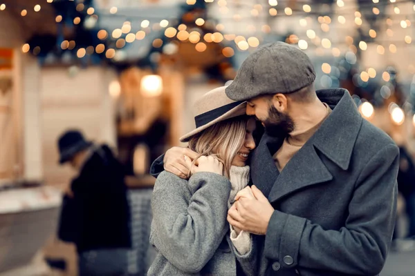 クリスマスのカップルはクリスマスに通りで抱きつく 愛の若いカップルがクリスマス休暇中に路上に立っていると抱擁 — ストック写真