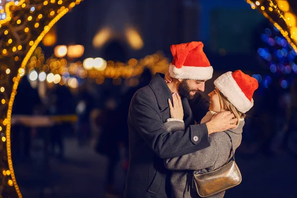 Noel Aşıkları Noel Arifesinde Sokakta Kucaklaşıyorlar Noel Baba Şapkalı Mutlu — Stok fotoğraf