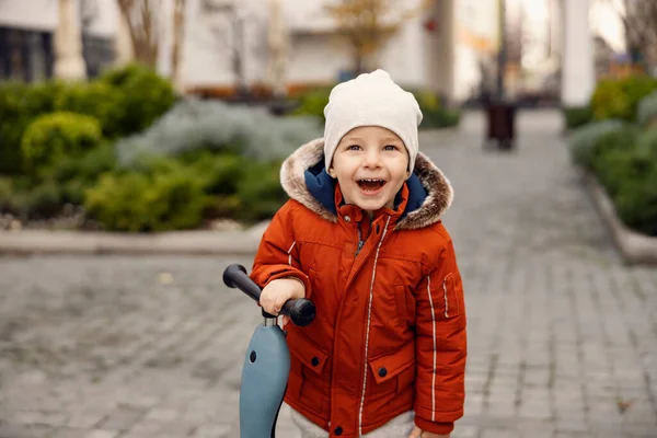 Счастливый Ребенок Веселится Скутером Улице Улыбающийся Маленький Мальчик Стоящий Улице — стоковое фото
