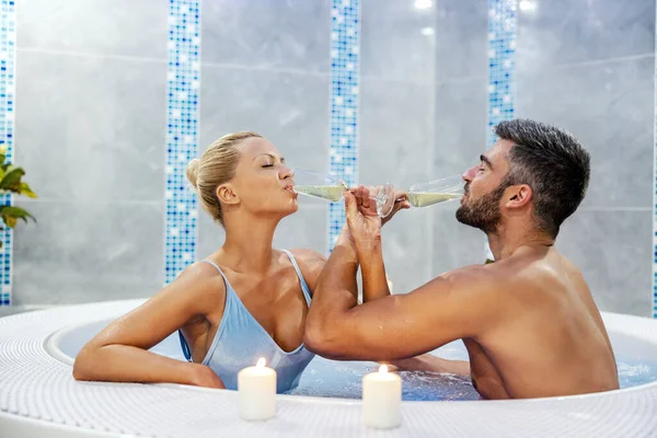 Romantic Couple Sitting Hot Tub Spa Center Drinking Champagne Arms — Zdjęcie stockowe