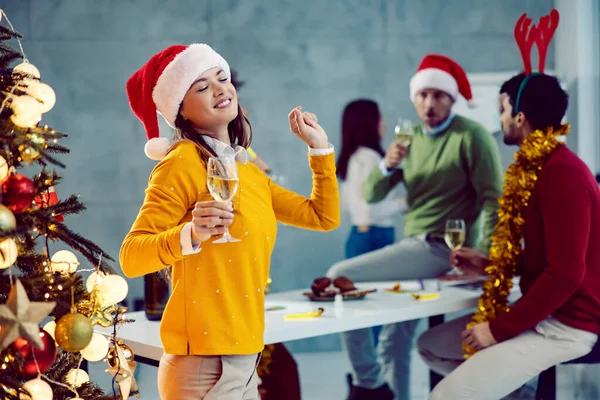 お正月の前夜祭 若い実業家が庭のクリスマスツリーの隣に立っていて ガラスのシャンパンを手にして踊っている — ストック写真