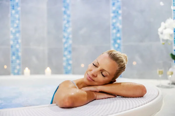 A woman relaxing in the hot tub with her eyes closed. Wellness and spa. Weekend in spa center. A woman in the hot tub.