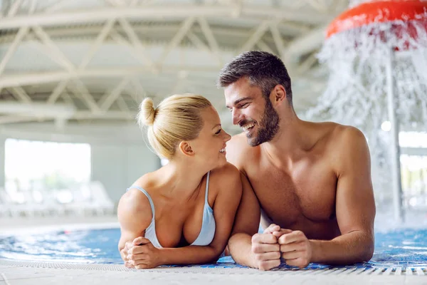 温水とミネラルウォーターを備えたプールに立つ素敵なカップルと目でお互いを見ています スパやウェルネスセンターでロマンチックな瞬間 スパのカップル — ストック写真