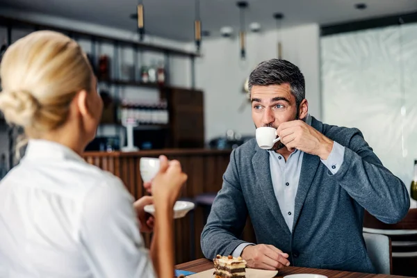 Een Man Met Een Baard Nipt Zijn Koffie Terwijl Hij — Stockfoto