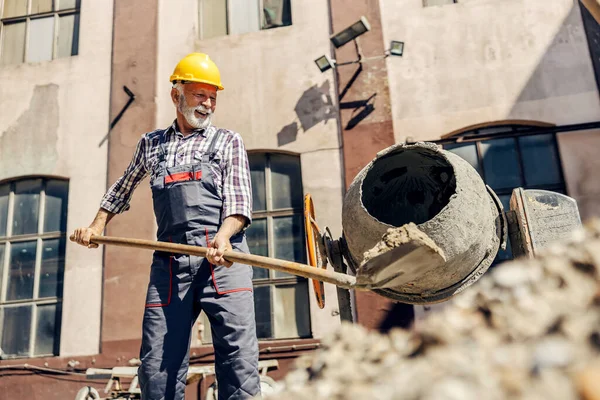 Starší Stavební Dělník Dává Cement Míchačky Cementu Zatímco Stojí Staveništi — Stock fotografie