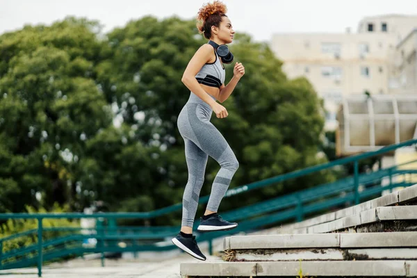 Una Donna Forma Corridore Con Cuffie Intorno Collo Corre Sulla — Foto Stock