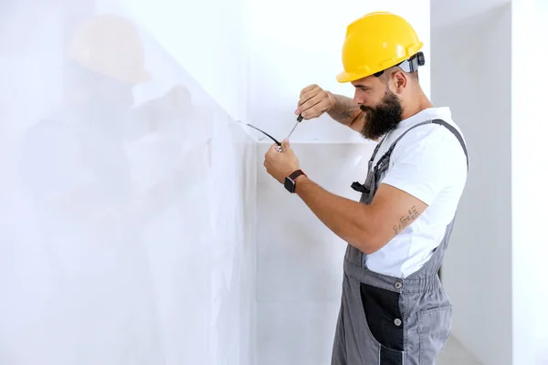 Egy Villanyszerelő Sisakkal Fején Vezetéket Köt Össze Egy Frissen Festett — Stock Fotó