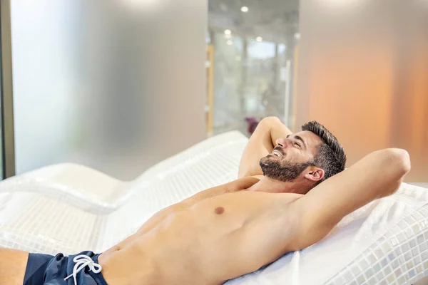 Счастливый Мускулистый Мужчина Купальнике Лежащий Кресле Спа Центре Расслабляющийся Wellness — стоковое фото