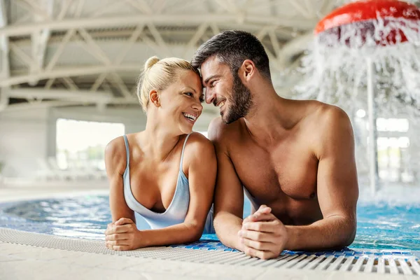温水プールで素敵なカップルが一緒に時間を楽しんでいちゃついています スパとウェルネスリゾートのカップル — ストック写真