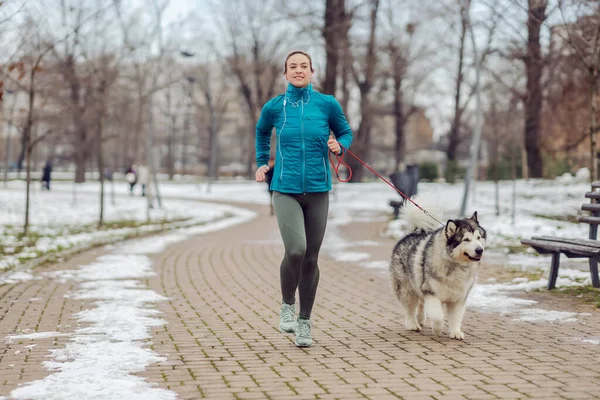 Sportswoman Jogging Insieme Con Suo Cane Nel Parco Tempo Nevoso — Foto Stock