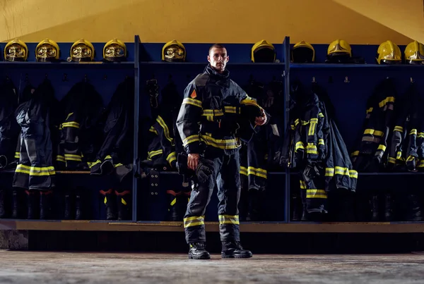 Bravo Jovem Bombeiro Quartel Bombeiros Uniforme Proteção Segurando Capacete Sob — Fotografia de Stock