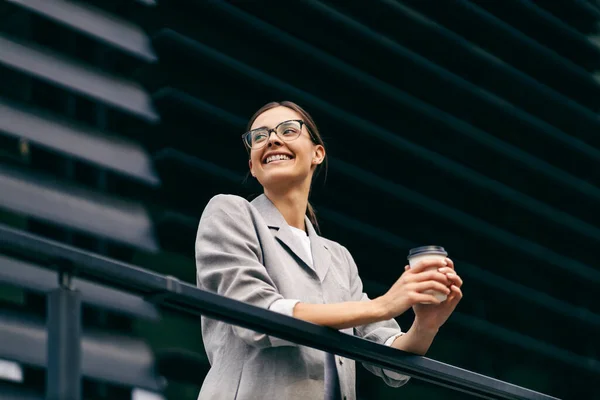 Szczęśliwa Elegancka Bizneswoman Opiera Się Balustradzie Tarasie Przerwę Kawę Trzyma — Zdjęcie stockowe