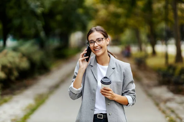 Egy Öltönyös Üzletasszony Áll Parkban Telefonál Ügyfelekkel Kávészünete Van Ezért — Stock Fotó