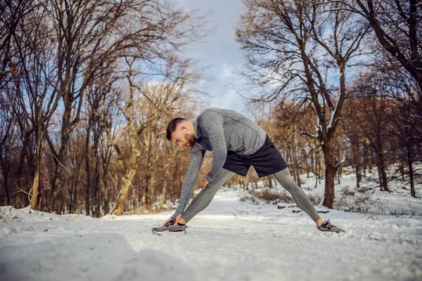 스포츠 선수는 눈내리는 겨울날에 스트레칭 연습을 속에서 준비를 스포츠 — 스톡 사진