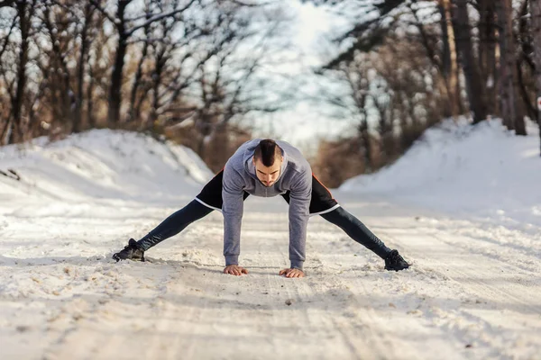 자연에서 눈덮인 위에서 따뜻하게 스트레칭하는 운동을 스포츠 선수의 모습이다 겨울의 — 스톡 사진
