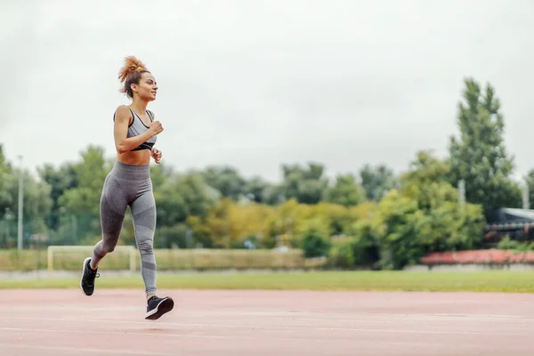 Una Chica Deportiva Con Pelo Rizado Corriendo Estadio Día Lluvioso — Foto de Stock