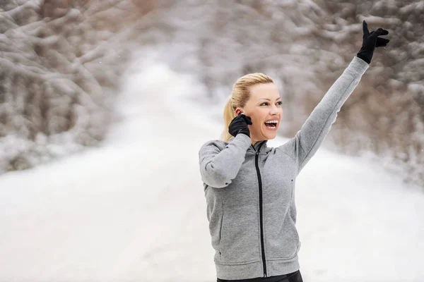 눈내리는 겨울날 속에서 이어폰을 음악을 즐기는 스포츠 — 스톡 사진