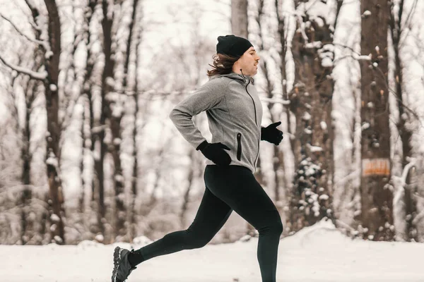 눈내리는 겨울날 속에서 달리는 단거리 선수의 마라톤 — 스톡 사진