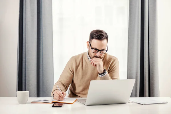 사업가가 자신의 사무실에 앉아서 노트를 노트북을 있습니다 — 스톡 사진