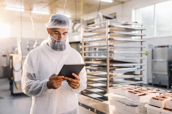 Operaio Una Fabbrica Alimentare Che Utilizza Tablet Controlla Cookie — Foto Stock