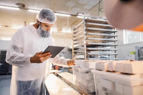 食品工場の監督者がタブレットを使用して食品の品質を評価する — ストック写真