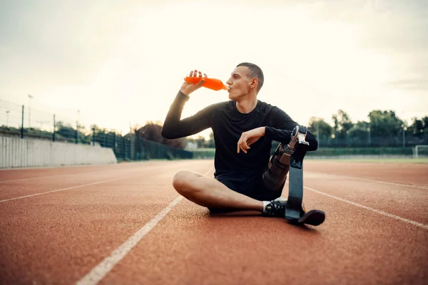 Protez Bacaklı Susamış Bir Koşucu Stadyumdaki Koşu Pistinde Oturur Içecek — Stok fotoğraf