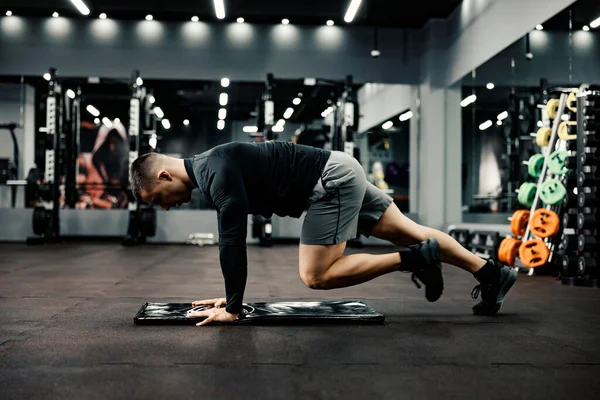 Formda Bir Adam Spor Salonundaki Paspasın Üstünde Isınma Egzersizleri Yapar — Stok fotoğraf