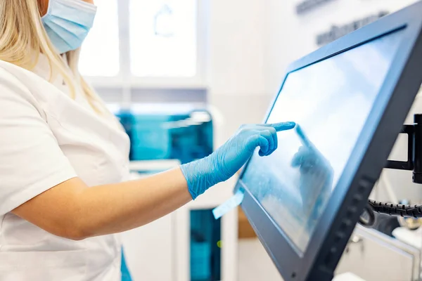 实验室里的现代技术一位护士站在一台分析血液样本并对其编程的机器旁边 护士触摸屏和编程机 — 图库照片