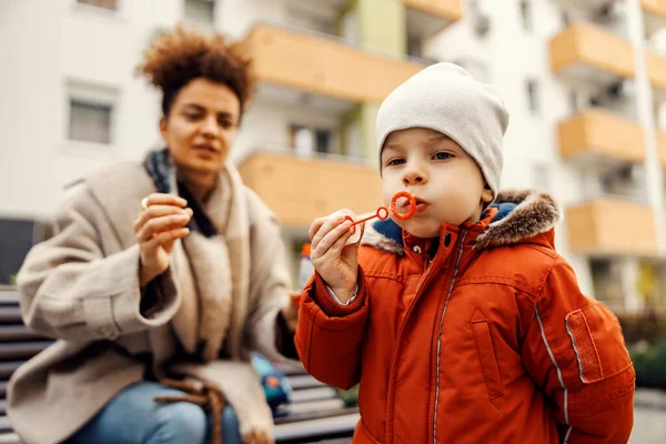 Child Blows Bubbles Park While His Babysitter Keeping Eye Him — Stock Photo, Image