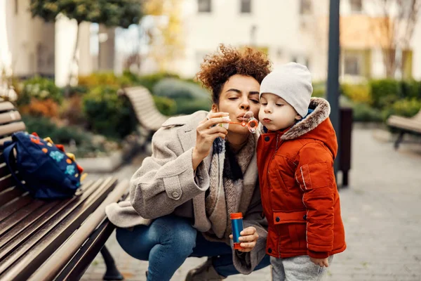 Menino Brincalhão Soprando Bolhas Parque Com Sua Babá — Fotografia de Stock