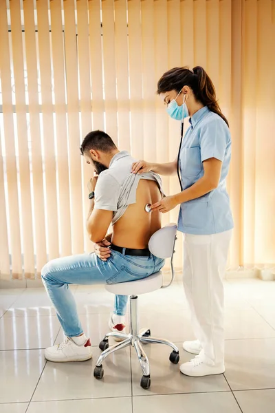 Een Vrouwelijke Dokter Die Longen Van Een Zieke Man Onderzoekt — Stockfoto