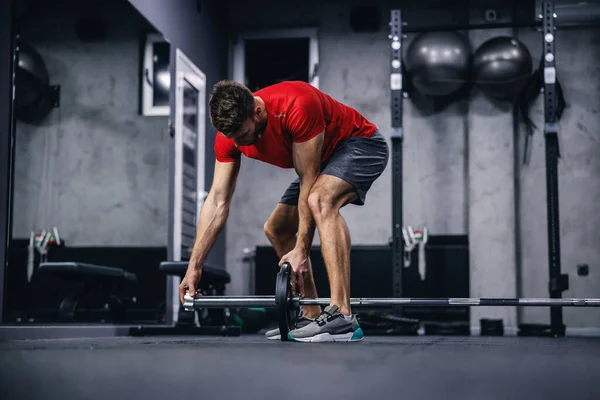 Kırmızı Tişörtlü Şortlu Yakışıklı Bir Adamın Modern Spor Merkezinde Eğitim — Stok fotoğraf