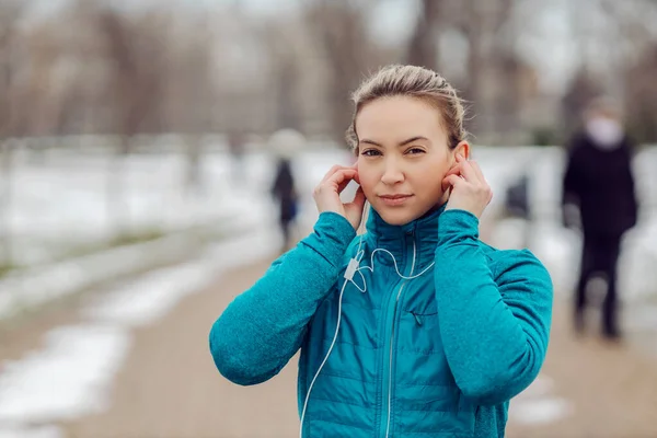 눈내리는 날씨에 공원에 이어폰을 스포츠 여성의 스포츠 — 스톡 사진