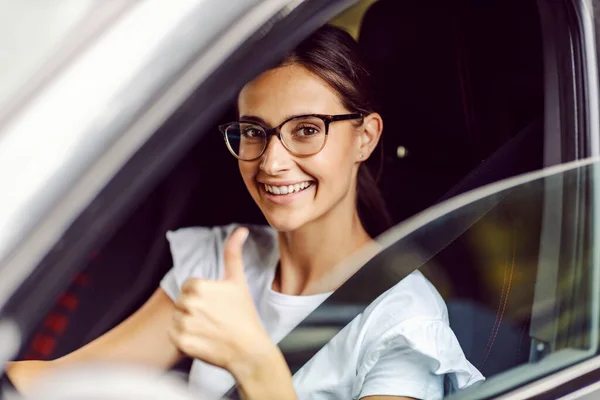 Μια Ευτυχισμένη Γυναίκα Γυαλιά Κάθεται Στο Αυτοκίνητό Της Και Δείχνει — Φωτογραφία Αρχείου
