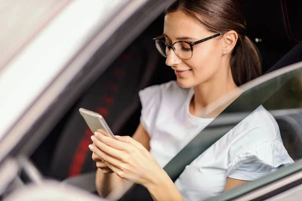 Uma Menina Sorridente Sentada Seu Carro Estacionado Usando Telefone Uma — Fotografia de Stock